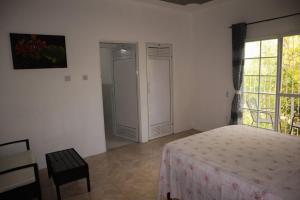 a white bedroom with a bed and a window at Kokojo Villa in Black River