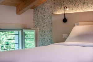 a bedroom with a white bed and a window at BORGO STALIS RESORT in Sesto al Reghena +91 photos