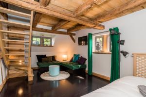 a room with a bed and a green couch at Maison Alsacienne 6p in Illkirch-Graffenstaden