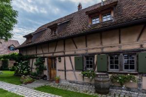 an old house with a barrel in front of it at Maison Alsacienne 6p in Illkirch-Graffenstaden