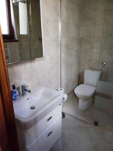 a bathroom with a white sink and a toilet at Терасите - Къща 2 in Ribarica +20 photos
