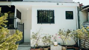 una casa blanca con macetas y una puerta negra en Gensan Apartment Rental, en General Santos