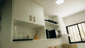 una cocina con armarios blancos y una ventana en Gensan Apartment Rental, en General Santos