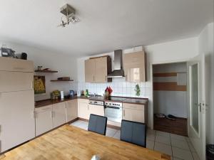 a kitchen with white cabinets and a wooden floor at Huge Private Room in Best Location in Düsseldorf