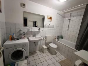 a bathroom with a sink and a washing machine at Huge Private Room in Best Location in Düsseldorf