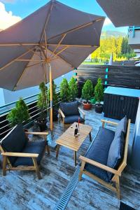 een patio met een tafel en stoelen en een parasol bij Silver Mountain B12 in Poiana Brasov