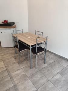 una mesa de madera con 4 sillas en la cocina en BEAU SOLEIL, en Amélie-les-Bains-Palalda