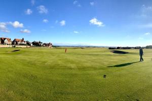 a man is standing on a golf green at Seaside spacious 4 BR Nr Town centre and Open Golf in West Kirby