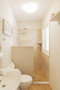 een witte badkamer met een toilet en een wastafel bij Villa Kira in Áfra