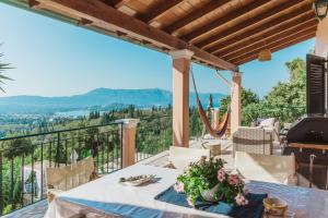 a table on a balcony with a view of the mountains at Villa Kira in Áfra