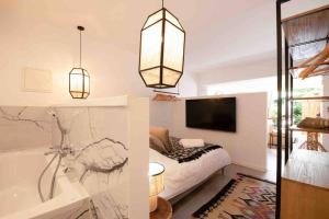 1 dormitorio con cama, bañera y TV en Suite de luxe 2 pièces golfe de Saint Tropez, en Sainte-Maxime