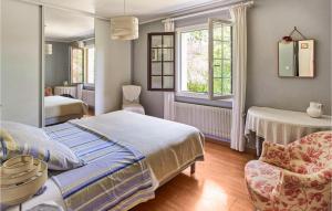 a bedroom with a bed and a chair and two windows at Amazing Apartment In Saint Jean De Luz in Costa Aldia