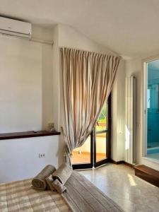 a bedroom with a bed and a large window at Casa Wizzy in Vico Equense