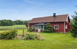 una casa roja en medio de un campo en 3 Bedroom Nice Home In Fjrs, en Fjärås