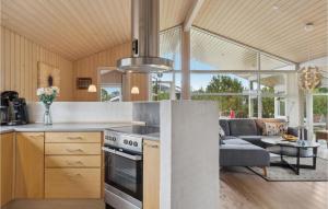 eine Küche und ein Wohnzimmer mit einem Herd und einem Sofa in der Unterkunft Lovely Home In Storvorde With Sauna in Egense