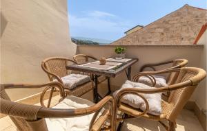 einen kleinen Balkon mit einem Tisch und Stühlen in der Unterkunft Gorgeous Home In Rab With House Sea View in Rab