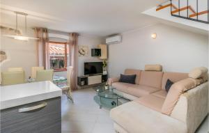ein Wohnzimmer mit einem Sofa und einem TV in der Unterkunft Gorgeous Home In Rab With House Sea View in Rab