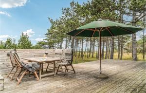a table and chairs and an umbrella on a deck at Nice Home In Sjllands Odde With House Sea View in Tjørneholm