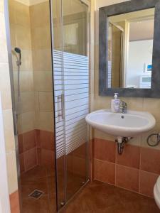 a bathroom with a sink and a shower at Apartamenty Familijne w Dąbkach in Dąbki