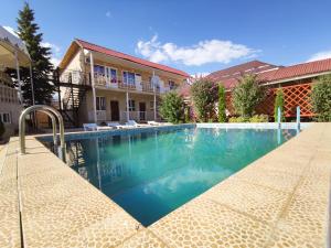 a swimming pool in front of a house at Адилет in Cholpon-Ata