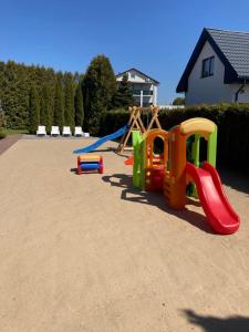 a playground with play equipment in a yard at Apartamenty Familijne w Dąbkach in Dąbki