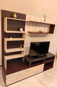 un soggiorno con TV e scaffali in legno di Leonidas Private Apartment in Sparta a Sparta