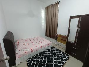 a bedroom with a bed and a dresser and a mirror at Mira Homestay Gurun - Pendang in Pendang
