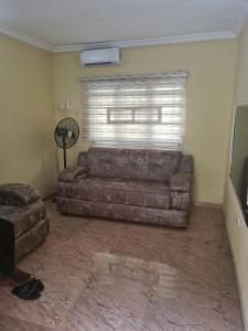 a living room with a couch and a fan at One bed apt Oluyole Akala express axis Ibadan in Ibadan