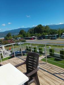 a black chair sitting on top of a wooden deck at Krapce - Lake View Apartments in Star Dojran