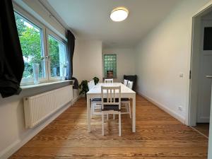 a dining room with a white table and chairs at Haus Nähe Hagenbecks Tierpark in Hamburg