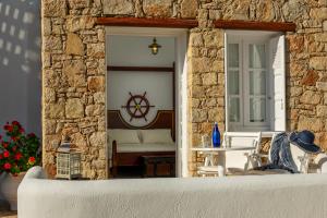 a stone building with a room with a bed and a table at Chora Resort Hotel & Spa in Chora Folegandros