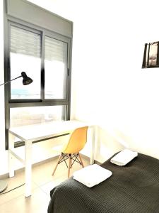 Vacation Apartment by The Sea - Achziv في نهاريا: غرفة نوم مع مكتب وسرير وكرسي