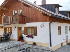Casa de madera con balcón y mesa en Ferienwohnung Auersbergsreut en Haidmühle