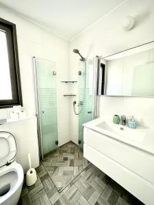 Vacation Apartment by The Sea - Achziv في نهاريا: حمام مع دش ومغسلة ومرحاض