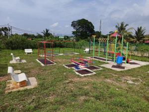 a playground with different types of play equipment in a field at Mira Homestay Gurun - Pendang in Pendang