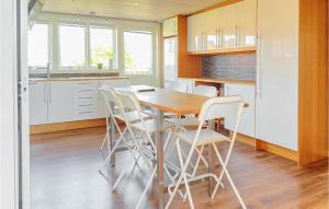 a kitchen with a wooden table and white chairs at 2 Bedroom Amazing Apartment In Visby in Visby