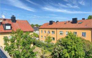 a yellow building with red roofs and trees at 2 Bedroom Amazing Apartment In Visby in Visby