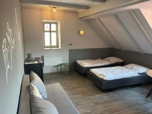 um quarto com duas camas e um sofá em Apartmány v lomnickém pivovaru em Lomnice nad Popelkou