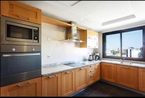 馬拉喀什的住宿－The Jade Apartment，厨房配有木制橱柜、微波炉和窗户。