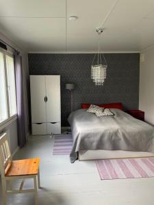 een slaapkamer met een bed, een stoel en een tafel bij Honkaranta in Jämijärvi