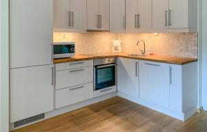 uma cozinha com armários brancos, um lavatório e um micro-ondas em Lovely Apartment In Geilo With Wifi em Geilo