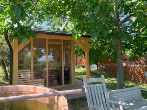 a gazebo with two white chairs in a park at Fügéskert in Balatongyörök