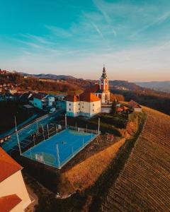 an aerial view of a church with a swimming pool and a building at Guesthouse Frlan in Ozalj