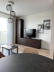 a living room with a black table and a tv at 2 room Apartment, new building, near Airport, Ovocné sady, in Prievoz