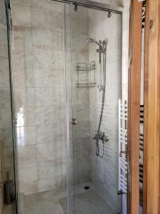 una doccia con porta in vetro in bagno di Терасите - Къща 3 a Ribarica