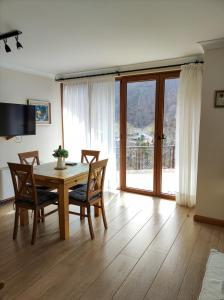 una sala da pranzo con tavolo, sedie e finestra di Терасите - Къща 3 a Ribarica
