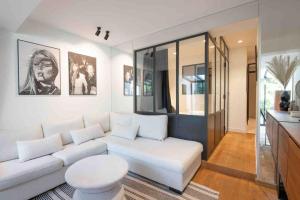 a living room with a white couch and a table at Golfe de St Tropez 3 pièces jardin piscine privée in Sainte-Maxime