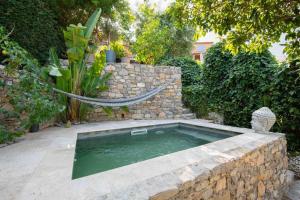 a swimming pool with a hammock in a garden at Golfe de St Tropez 3 pièces jardin piscine privée in Sainte-Maxime