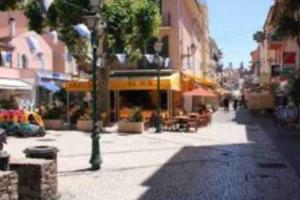 a city street with buildings and a street with a tree at Golfe de St Tropez 3 pièces jardin piscine privée in Sainte-Maxime