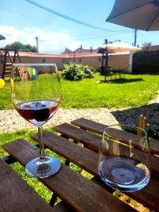two glasses of wine sitting on a wooden table at Porumbacu381 - Casa de Oaspeti Faini in Porumbacu de Sus